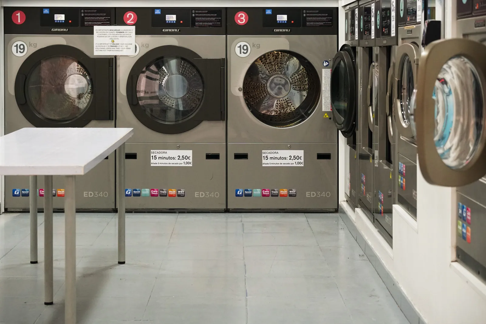Row of numbered commercial front-load laundry machines